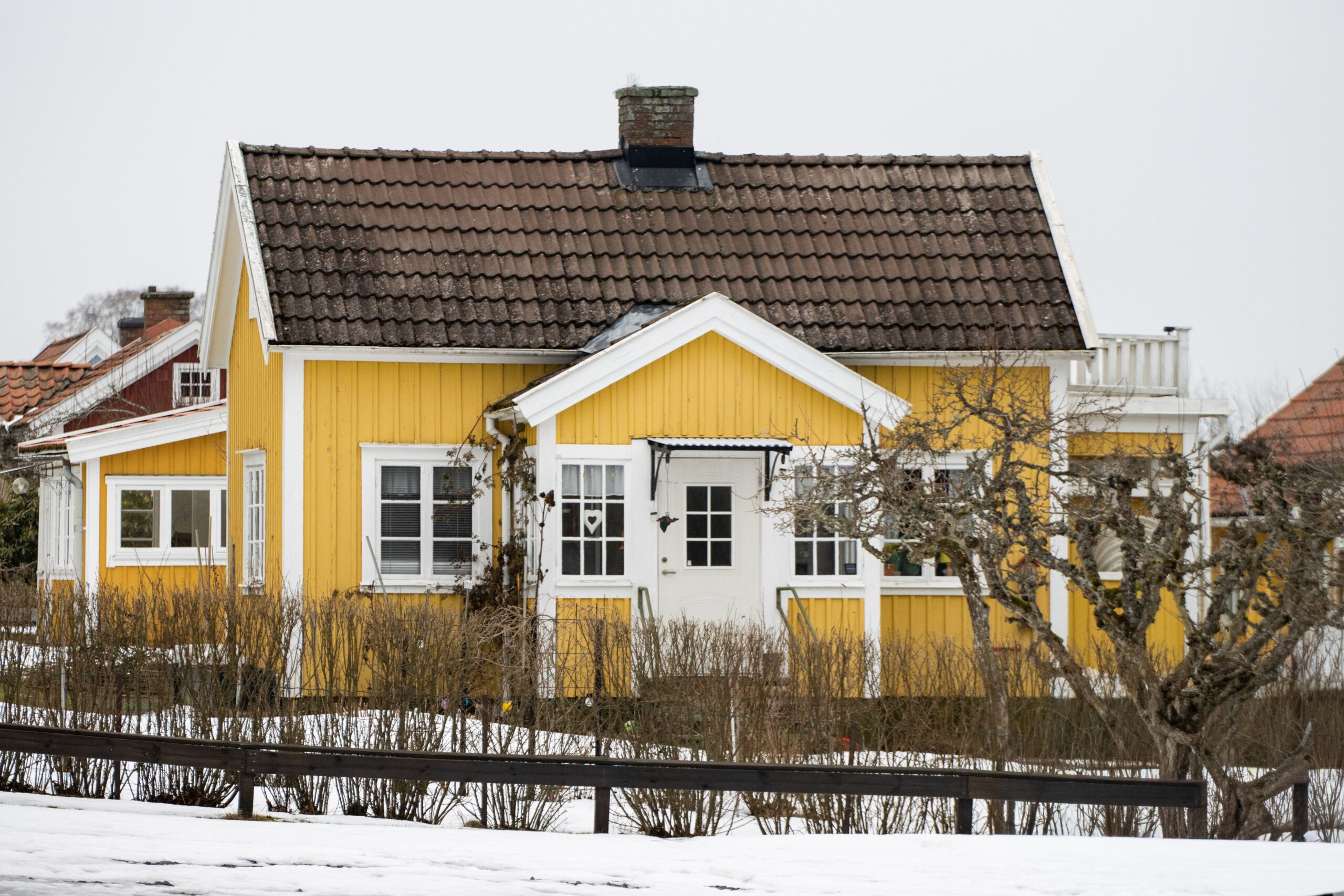 Keltaisen omakotitalon ulkomaalaus Helsingissä